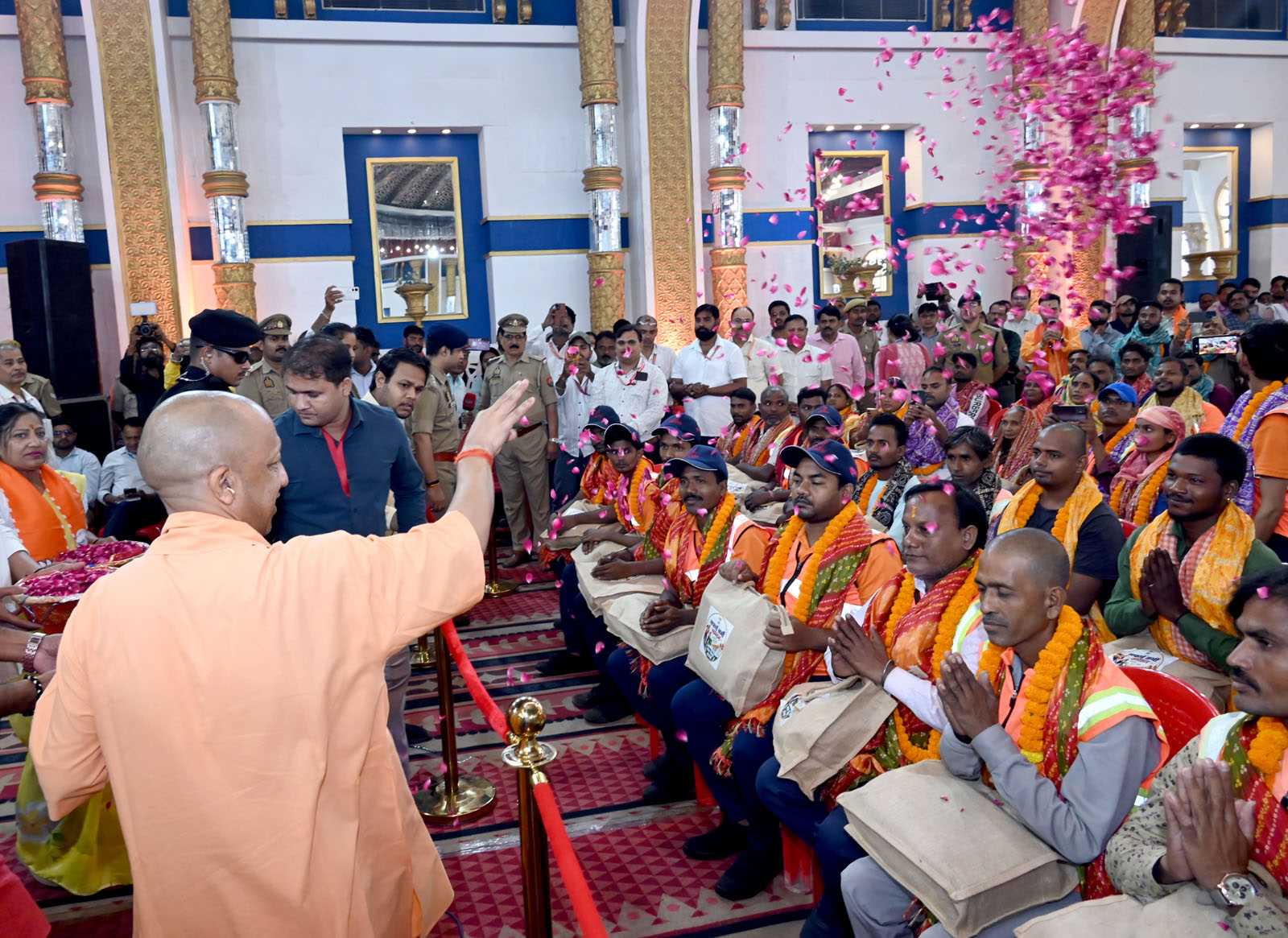 Hon'ble Chief Minister Yogi Adityanath showering flowers on sanitation workers at the Sanitation Workers' Felicitation Ceremony held at Saroja Palace, Kabirchaura, Varanasi on October 15, 2026.