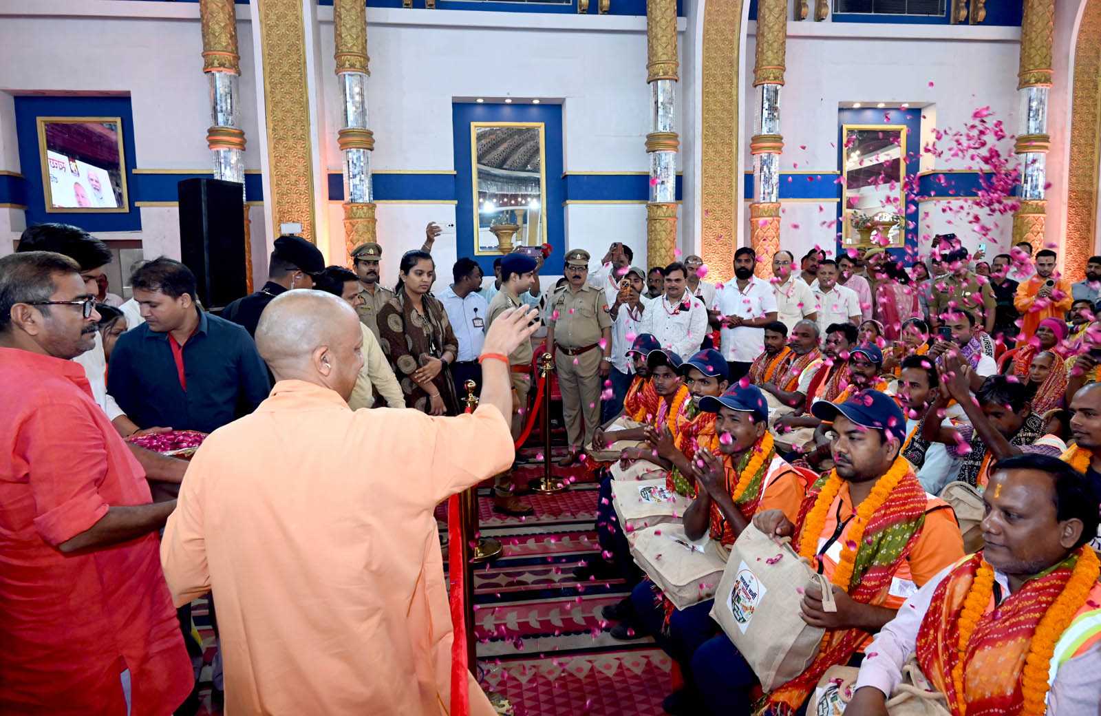 Hon'ble Chief Minister Yogi Adityanath showering flowers on sanitation workers at the Sanitation Workers' Felicitation Ceremony held at Saroja Palace, Kabirchaura, Varanasi on October 15, 2026.