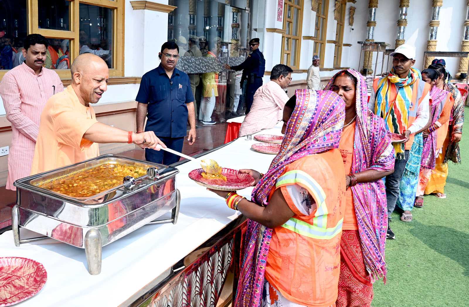 Hon'ble Chief Minister Yogi Adityanath serving food to sanitation workers at the Sanitation Workers' Felicitation Ceremony held at Saroja Palace, Kabirchaura, Varanasi on October 15, 2026.
