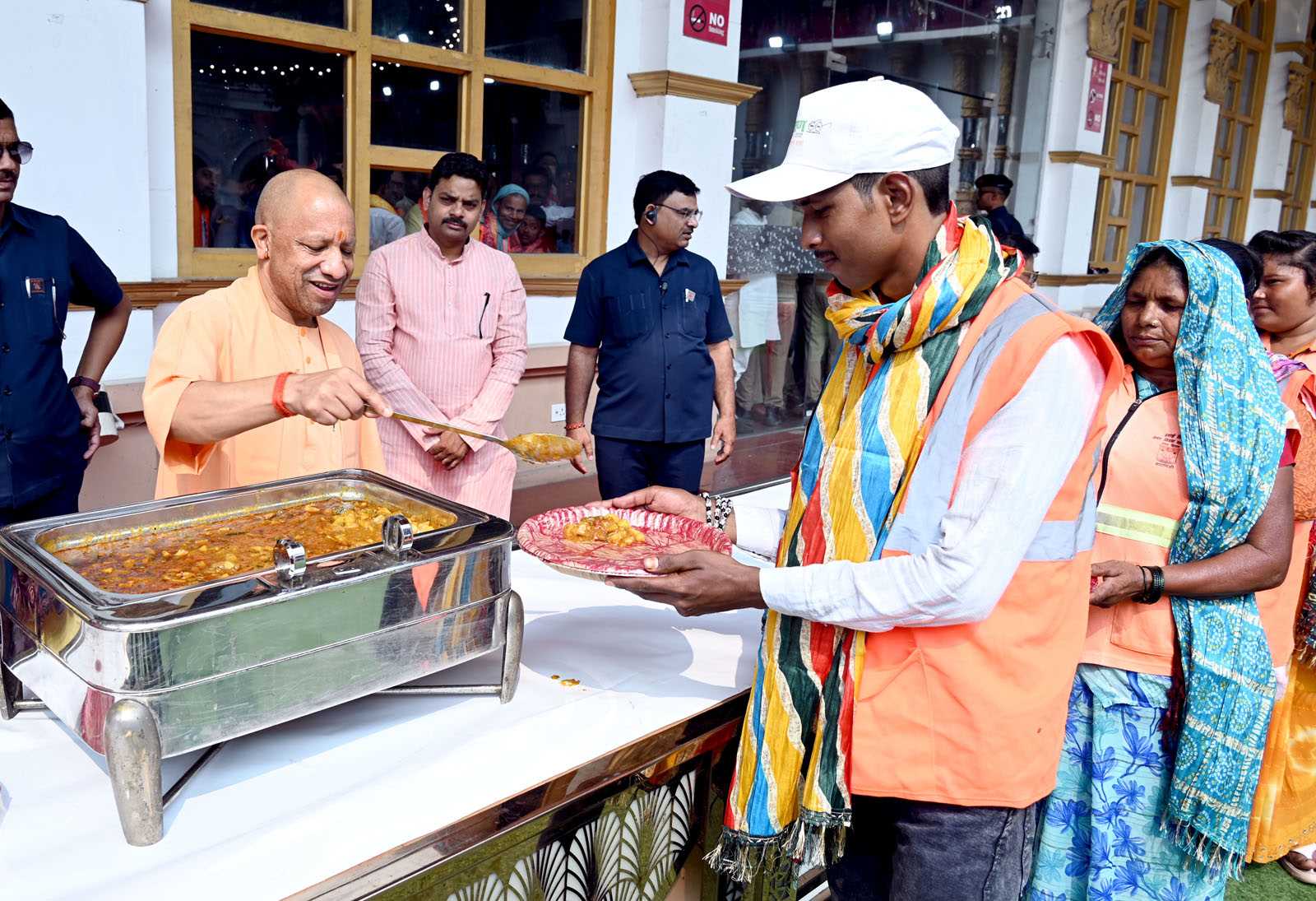 Hon'ble Chief Minister Yogi Adityanath serving food to sanitation workers at the Sanitation Workers' Felicitation Ceremony held at Saroja Palace, Kabirchaura, Varanasi on October 15, 2026.